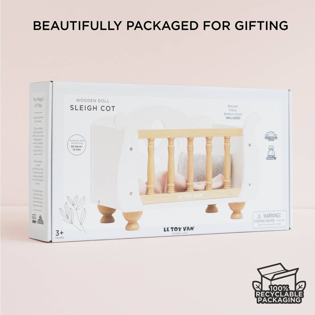A white Wooden Dolls Cot inside its retail packaging box.