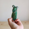 A hand holds the Felt Gator Finger Puppet, shaped like a crocodile with big round eyes and a red stitched smile—perfect for imaginative play or storytelling—against a light background.