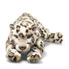 The Steiff XL Parddy Snow Leopard 21" plush features white fur with brown and black spots, light blue eyes, and a lying pose with extended front paws. This lifelike big cat toy includes a small tag on its side.
