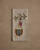 The Coral & Tusk Deck the Halls Bear Tea Towel showcases an embroidered bear in festive attire standing on an ornament with a pine branch, adding cheerful holiday charm to your kitchen décor.