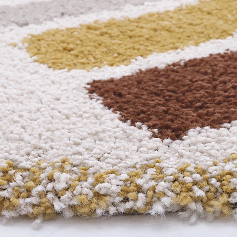 Close-up of the Bohemian Rainbow Children's Rug - Final Sale, featuring a thick, plush white base with large mustard yellow and brown geometric shapes—soft and textured for a cozy, playful touch in any kid's space.