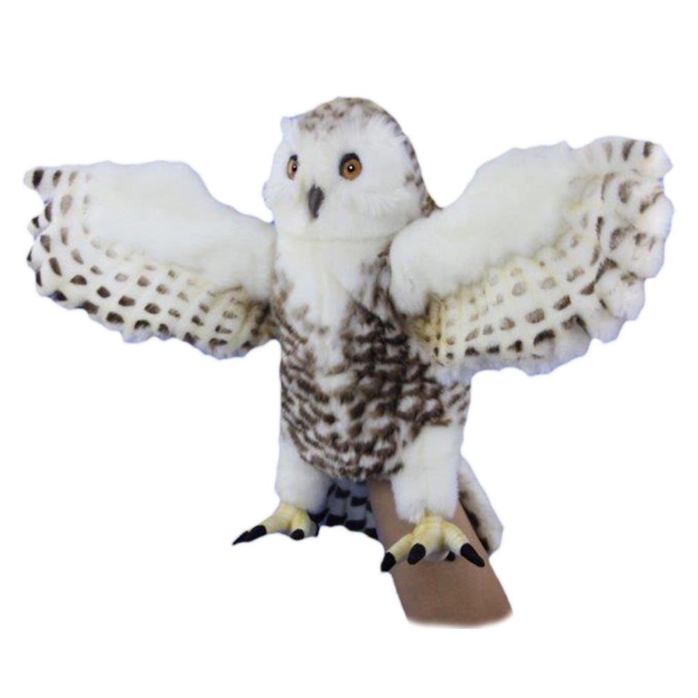 The Snowy Owl Puppet features realistic details, white and brown spotted feathers, yellow eyes, and wide-spread wings. It sits on a tan stand against a white background.