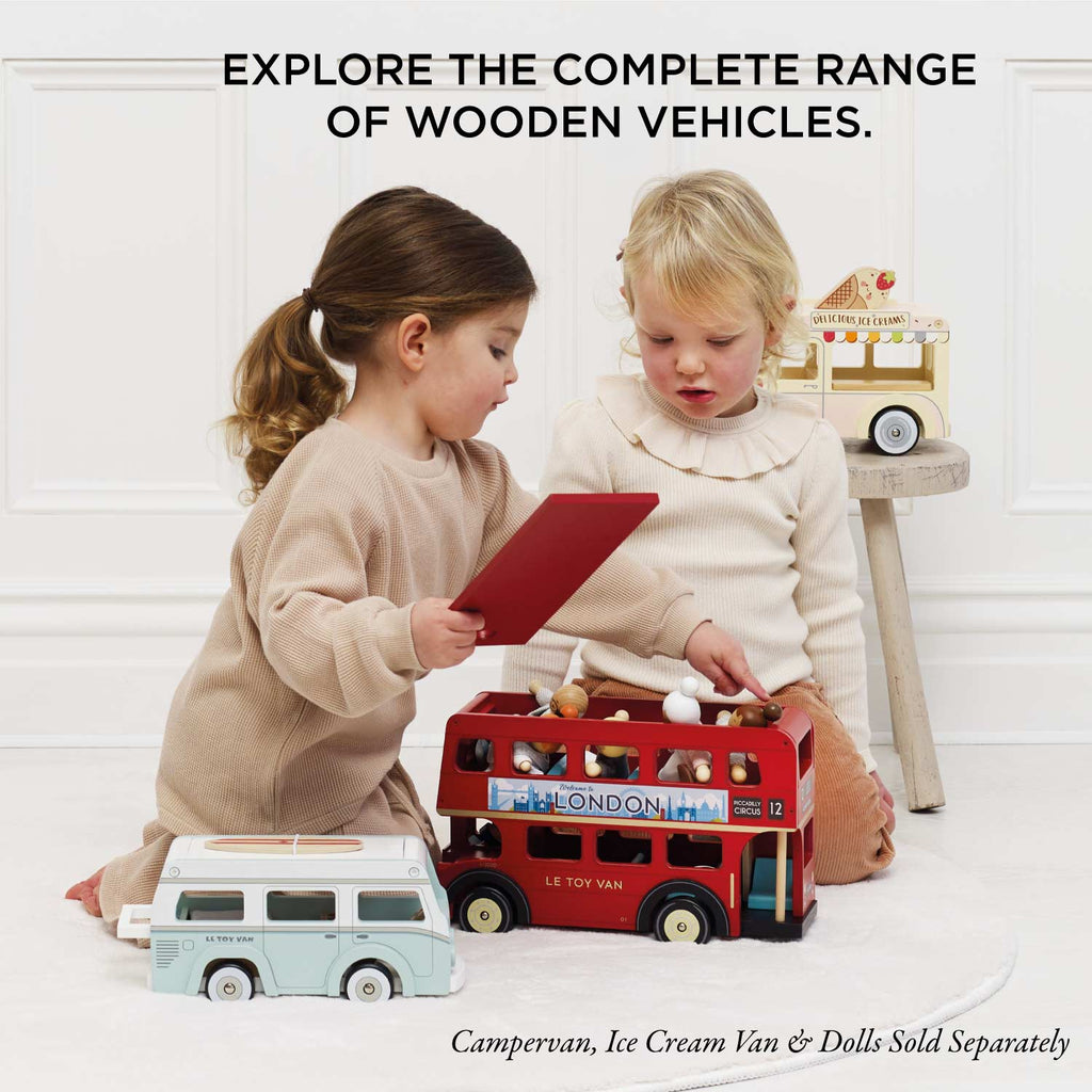 Two young children play with a London Wooden Bus and other wooden vehicles. Text above: "EXPLORE THE COMPLETE RANGE OF WOODEN VEHICLES." Perfect for early learning play.