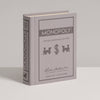 The Monopoly Vintage Bookshelf Edition is a gray hardcover book featuring premium game components, the game's title, classic game piece icons, and age/player info on the front cover.