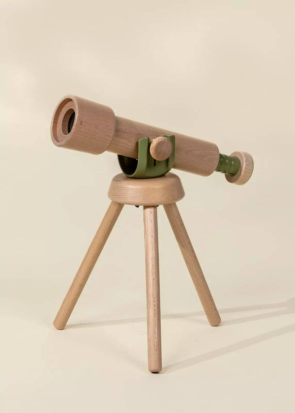 The Wooden Tripod Telescope – 15x Zoom features green accents and a sturdy three-legged base, ideal for pretend play adventures. Shown against a plain beige background, it offers young explorers exciting magnified views.