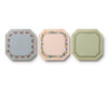 The Gemma Mini Notepad Trio includes three octagonal notepads with decorative floral and leafy borders in blue, pink, and green tones, accented with metallic gold details, displayed side by side against a white background.