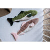 Two Senger Naturwelt Cuddly Animal - Fish toys, one green and one pink with brown, rest side by side on a white textured crib blanket—a charming, sustainable addition to your nursery.