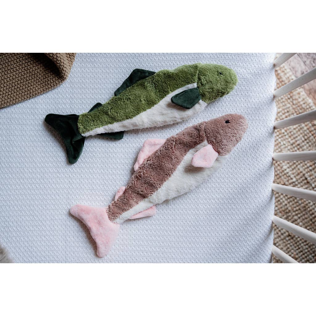 Two Senger Naturwelt Cuddly Animal - Fish toys, one green and one pink with brown, rest side by side on a white textured crib blanket—a charming, sustainable addition to your nursery.