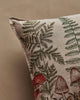 A close-up of the Coral & Tusk Mushrooms and Ferns Lumbar Pillow, featuring green ferns and red mushrooms on a beige fabric background.