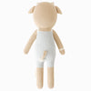 The Cuddle + Kind Asher The Cow is a hand-knit cotton plush toy shaped like a light brown cow, shown from the back in light blue overalls. It features small horns, a tail, hypoallergenic polyfill, and no visible face in this view.