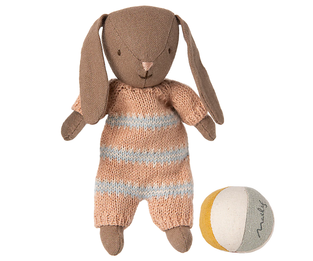 The Maileg Micro Bunny With Ball - Brown - Dusty Rose (Magnetic Hands) sits beside a small round fabric ball with white, yellow, and gray segments—a charming storytelling toy on a white background.