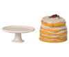 The Maileg Party Cake and Cake Stand, Mouse - Off White (expected 05/01/26), is a charming addition for parties, featuring a petite white stand ideal for displaying toy cakes or treats against a clean white background.