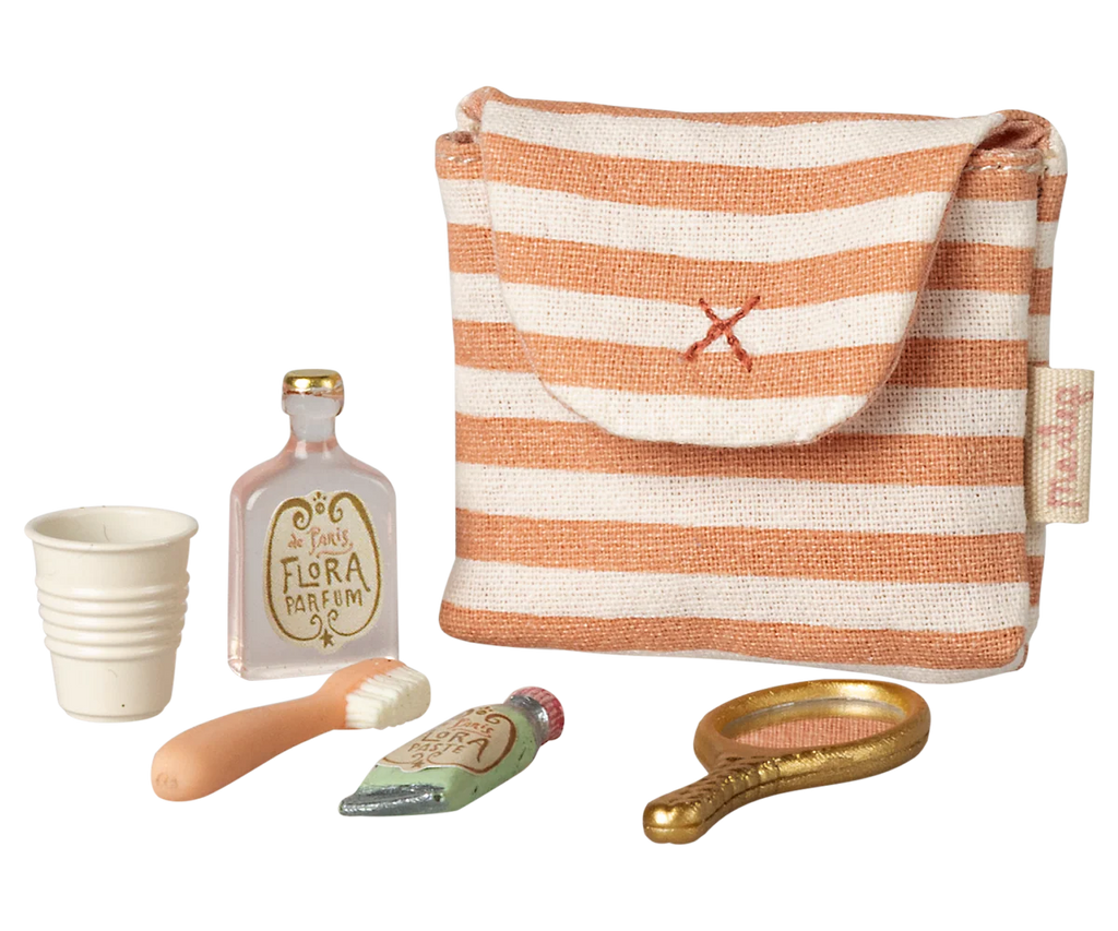 The Maileg Toothbrush Set in Bag, Mouse - Coral Stripe (arriving 04/15/26) features a striped toiletry bag with a white cup, pink perfume bottle, tiny brush, cream tube, and gold hand mirror—great for mouse family or bedtime play.
