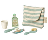 The Maileg Toothbrush Set in Bag, Mouse - Blue Stripe (expected 04/15/26) includes a striped pouch with a tiny shampoo, toothpaste, toothbrush, cup, and hairbrush—perfect pastel accessories for your mouse family's toiletry kit.