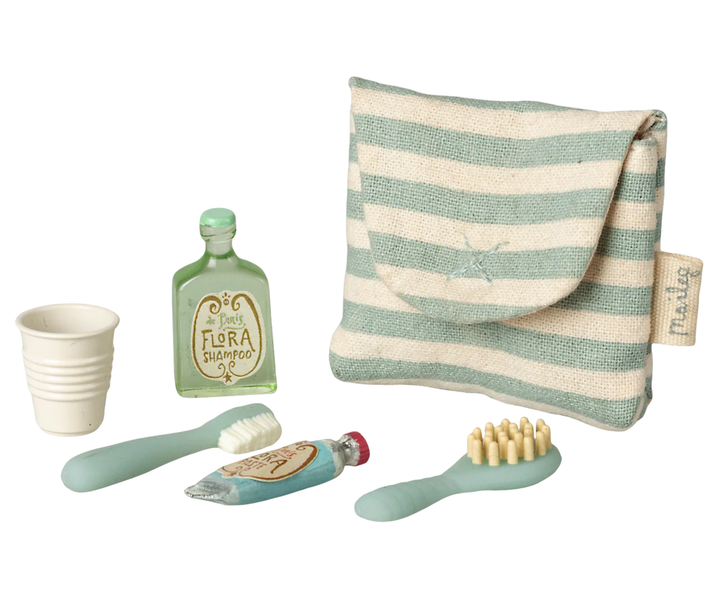 The Maileg Toothbrush Set in Bag, Mouse - Blue Stripe (expected 04/15/26) includes a striped pouch with a tiny shampoo, toothpaste, toothbrush, cup, and hairbrush—perfect pastel accessories for your mouse family's toiletry kit.