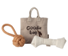 A beige Maileg Pet Supply tote labeled "Goodie bag" sits on a white background, with an illustrated dog, rope knot toy, and magnetic puppy bone from the Toys set (Expected arrival: 03/15/26) displayed in front.