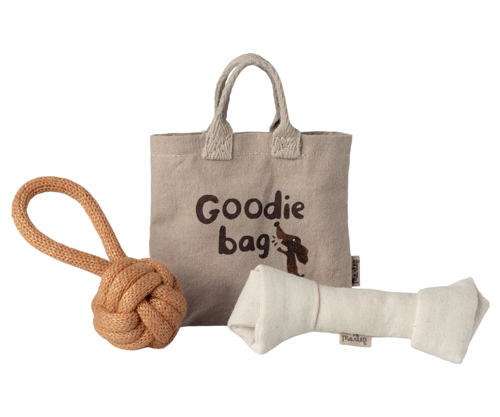 A beige Maileg Pet Supply tote labeled "Goodie bag" sits on a white background, with an illustrated dog, rope knot toy, and magnetic puppy bone from the Toys set (Expected arrival: 03/15/26) displayed in front.