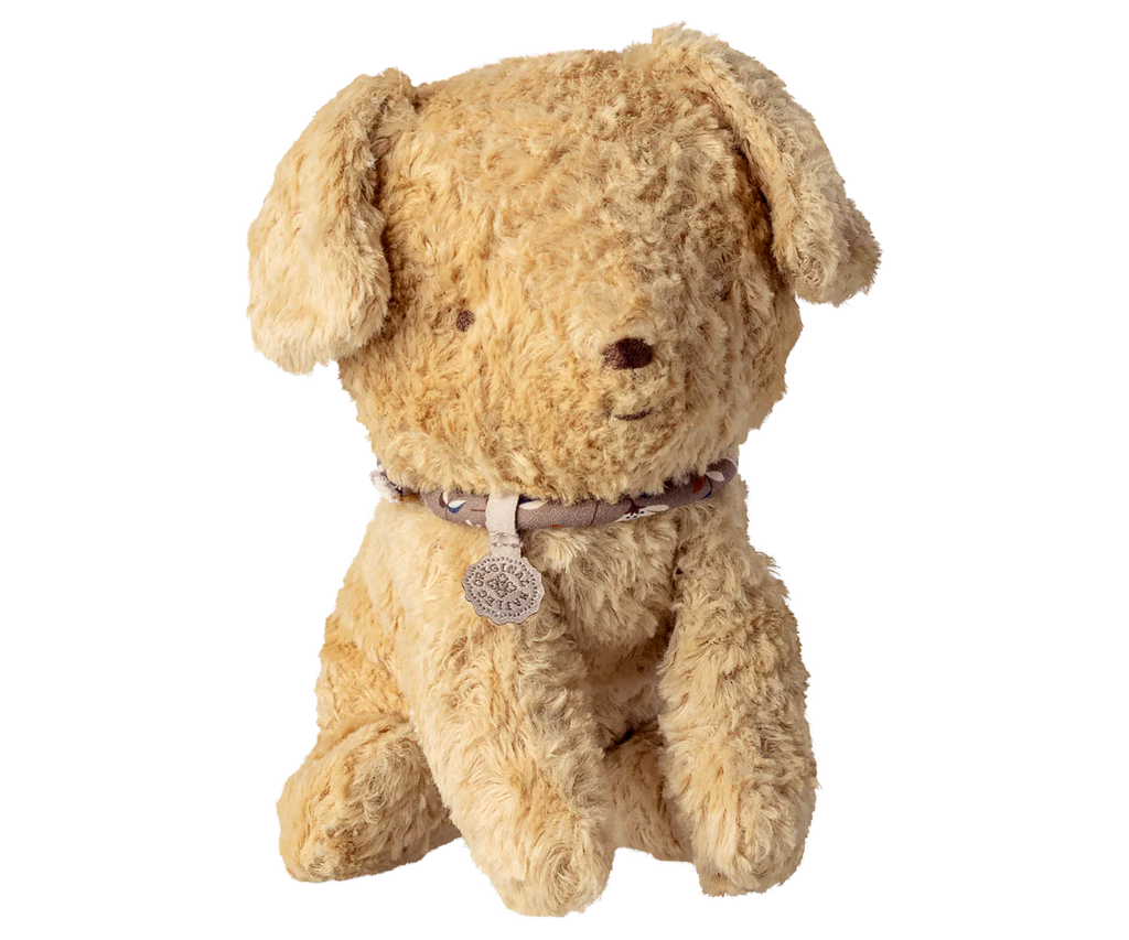 The Maileg Puppy, Small - Soft Sand is a plush, light brown dog with floppy ears, black eyes, a round nose, and a beige collar with a small round tag. Background is plain white.