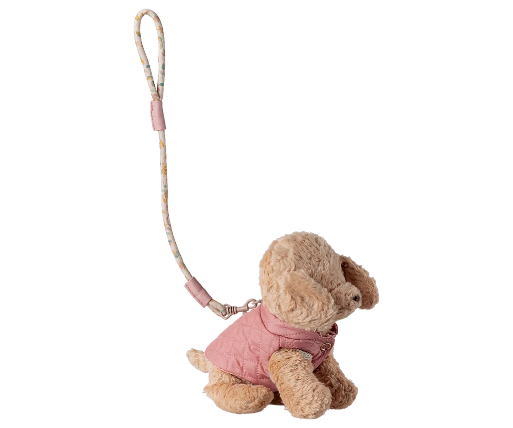 The Maileg Pet Supply, Harness and Leash - Rose features a cute, soft puppy plush in a pink quilted jacket attached to a patterned wrist strap—perfect for fans of adorable dog accessories. Expected arrival: 03/01/26.