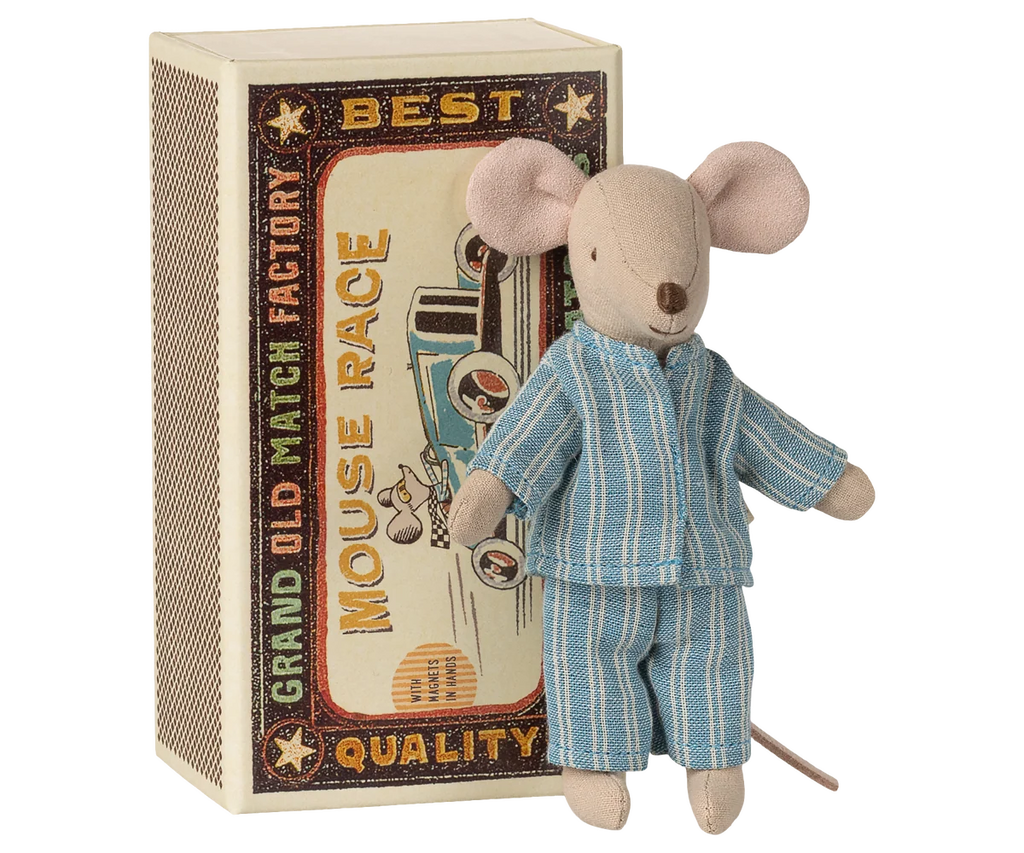 Maileg Big Brother, Mouse In Matchbox features a soft fabric mouse dressed in blue striped pajamas, standing in front of a large decorative matchbox labeled “Grand Old Match Factory Best Quality Mouse Race.” Reminiscent of the classic Maileg design, this charming toy exudes vintage whimsy and delightful detail.