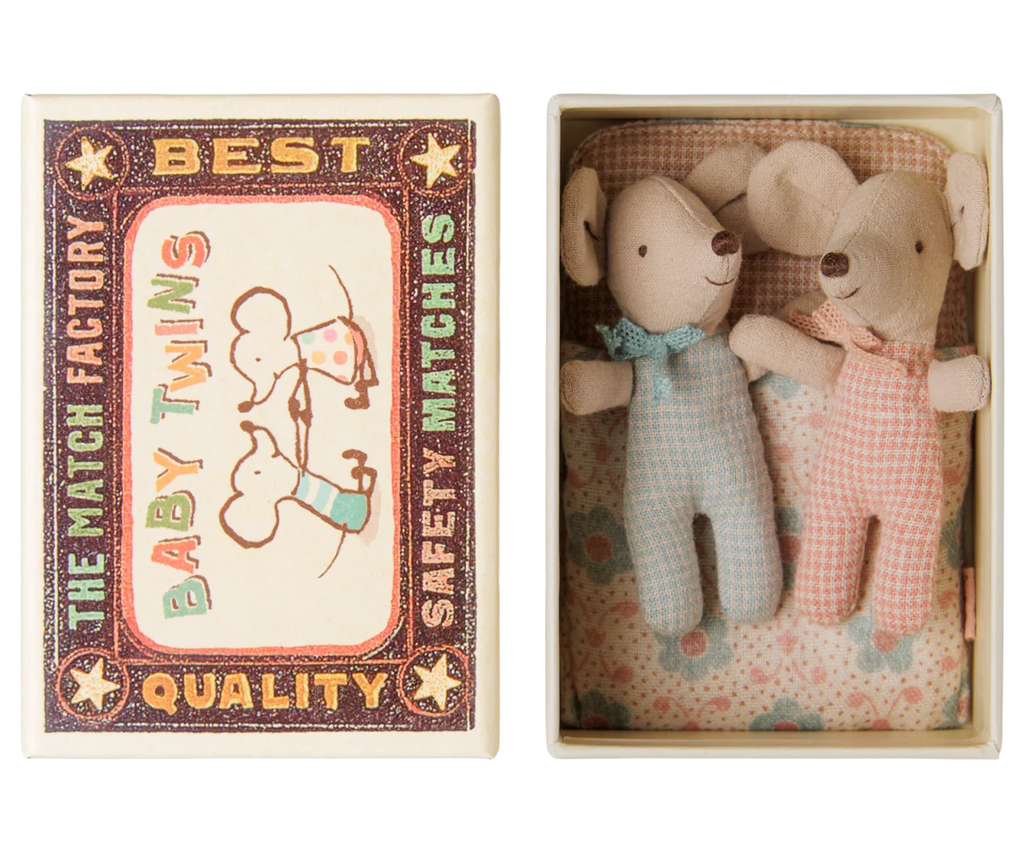 The “PMaileg Twins, Baby Mice in Matchbox - Checker” set features two sweet baby mice nestled inside a patterned matchbox bed, one dressed in blue and the other in pink. The charming box is adorned with checker designs and vintage-style illustrations, creating a delightful miniature scene.