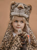 A young child dressed in the Costume - Leopard, featuring a faux fur leopard print with hood and paws, stands against a plain brown background holding a dandelion—an adorable and unique kids gift idea.