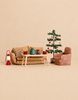 Maileg Christmas Living Room Set featuring a sofa and armchair with patterned upholstery, a coffee table with a teapot and cake, a small decorated Christmas tree, and a red lantern.