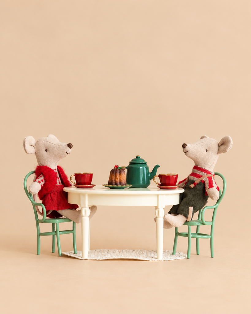 Maileg Christmas Mice Set twins sit at a vintage dining table with a teapot, cups, and a dessert.