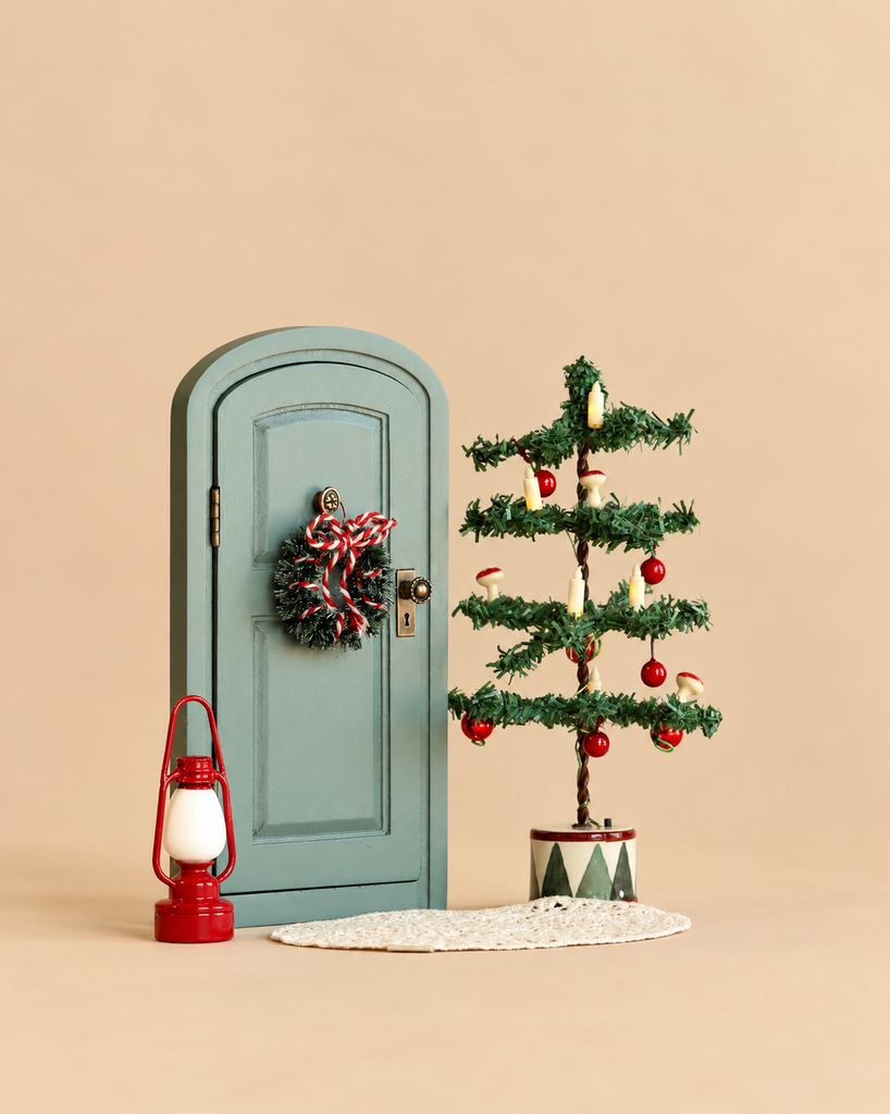 A miniature green Maileg Christmas Set featuring a small wreath, a tiny decorated tree with ornaments and candles, and a mouse-size red lantern.