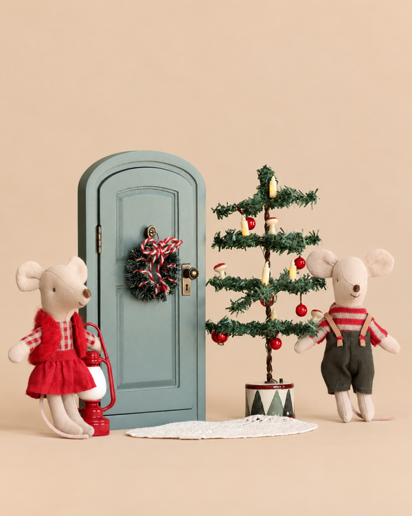 Maileg Christmas Mice Set twin mice stand beside a miniature green door decorated with a wreath, a small Christmas tree, and a red lantern.
