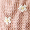 Close-up of Cuddle + Kind Daisy the Kitten's pink premium cotton knit, featuring two small white and yellow embroidered flowers.