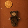 An Olli Ella Dinky Dinkum Doll - Wesley Werewolf in a fuzzy brown costume lying on a reddish-brown background with a golden moon and several small stars.
