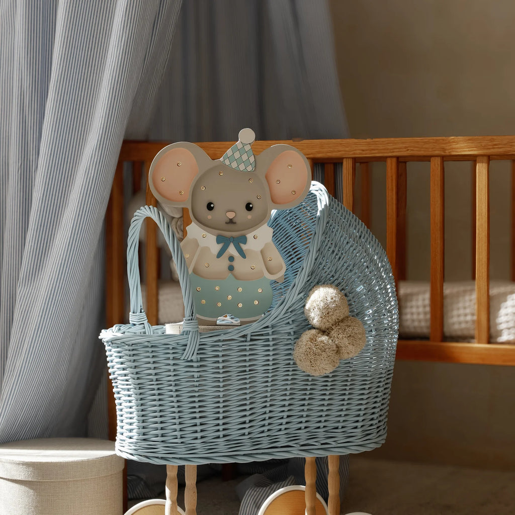 A handmade wooden lamp featuring Felix the Mouse in a blue outfit and party hat adds charming, softly lit decor to any nursery, perfectly complementing cribs and light curtains.