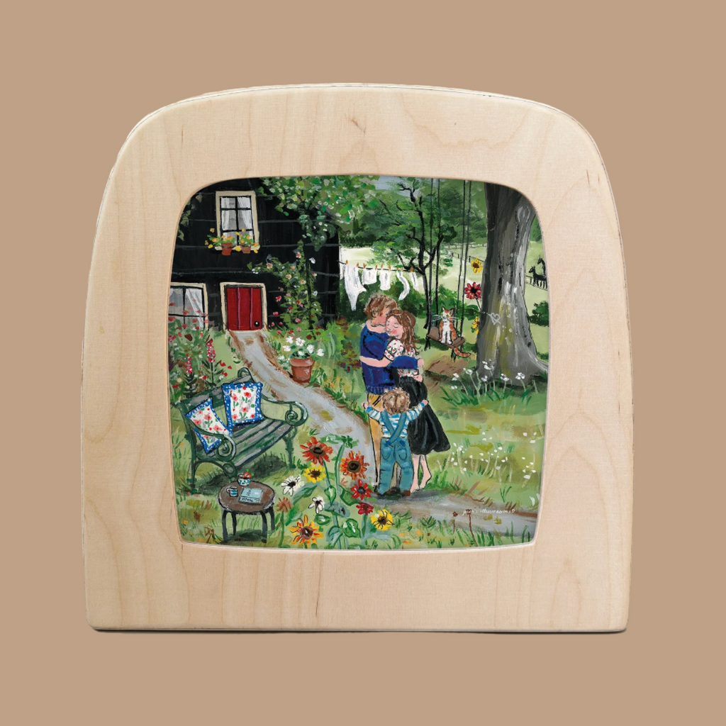 The Silhouette Only - Love's Embrace for Toverlux Lamp captures a serene home atmosphere with two adults and a child in a flower-filled garden. A path leads to a black house with a red door, chairs with cushions invite relaxation, and laundry dances on the line like Magic Silhouettes.