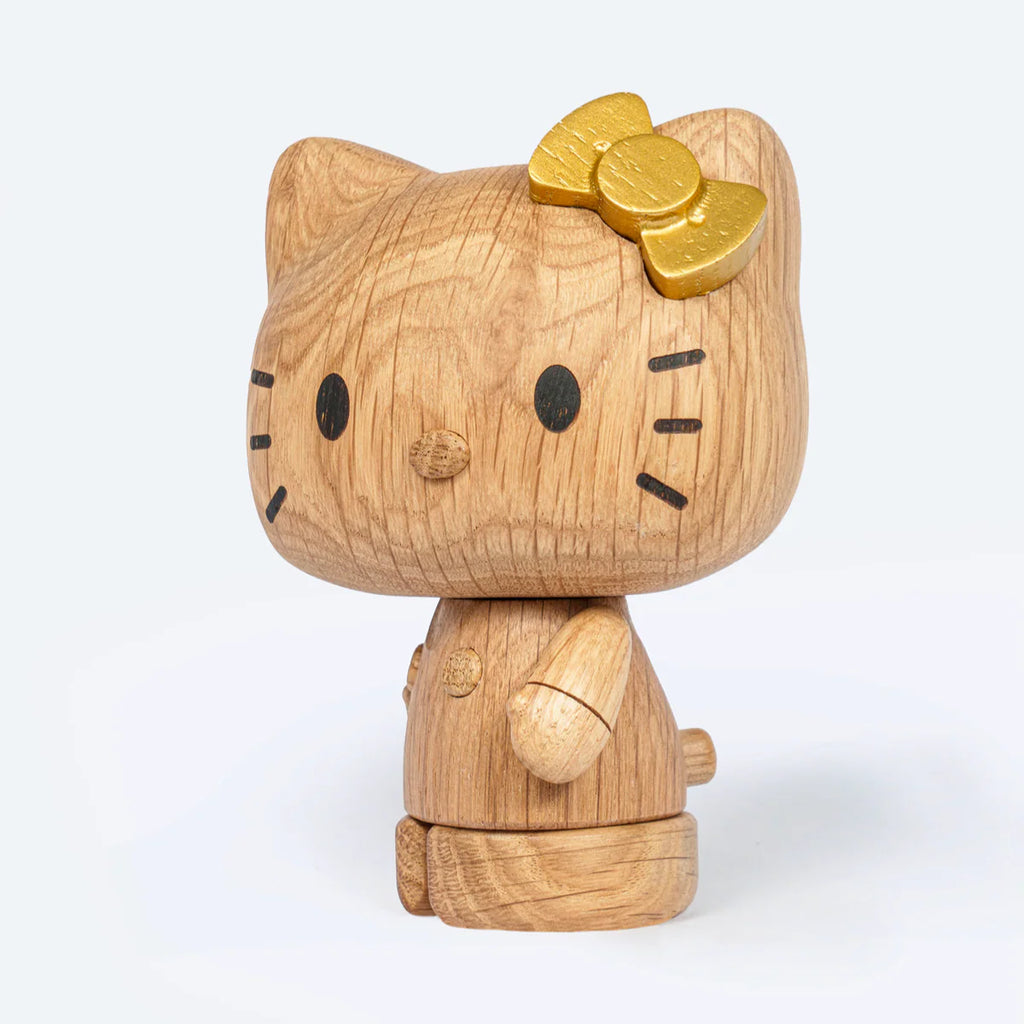 The Boyhood Hello Kitty 50th Anniversary Limited Edition features Hello Kitty with a gold bow on her left ear, black eyes, nose, and whiskers, standing against a plain light background.