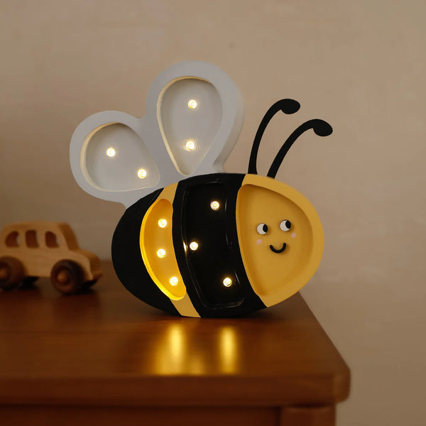 The Handmade Wooden Mini Lamp - Happy Bee features a smiling face and glowing bulbs on its wings and body. With black antennae, it’s perfect as a children’s night light or charming kids’ room decor. Sits nicely on any wooden surface.