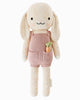 Cuddle + Kind Harper the Bunny is a hand-knit doll from premium cotton, featuring long floppy ears, a happy face, and pink overalls with a carrot in the pocket. Handmade in Peru.