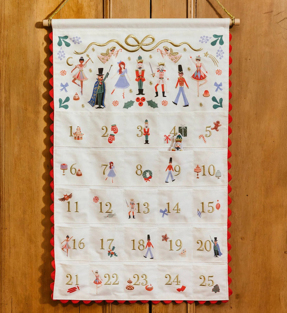 Nutcracker Embroidered Hanging Advent Calendar - Red featuring embroidered nutcracker figurines and pockets numbered one through twenty-five.