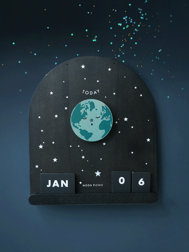 The Me & The Moon – Moon Phase Calendar features a rotating Earth, magnetic moon discs, and star details. “Today,” “JAN,” and “06” are displayed amid confetti-like accents, giving this wooden calendar a celestial, space-inspired feel.