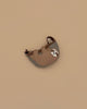 The Donsje Leather Talei Bumbag Purse - Sloth is a small, brown and gray kids bag shaped like a smiling sloth, featuring an adjustable strap, shown on a plain beige background.