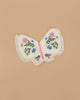 The Meri Meri Butterfly Wings feature ruffled edges and vibrant embroidered flowers on the wings, set against a plain beige background.