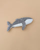The Senger Naturwelt Cuddly Animal - Whale, crafted from organic cotton in gray and white, sits on a beige background and doubles as a cozy handmade warming pillow.