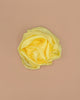 The Sarah's Silks Solid Color Playsilk - Sunshine, made from 100% pure yellow silk and artfully shaped like a rose on a beige background, is perfect for open-ended play.