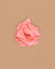 A peach heavy pure silk fabric, folded and arranged like a rose, sits against a plain light brown background—perfect for open-ended play with Sarah's Silks Heavy Playsilk Large - Peach.