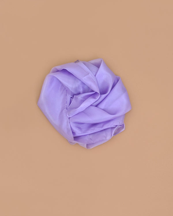 Sarah's Silks Solid Color Playsilk in Lavender, inspired by Playsilks, is displayed in a circular arrangement on a plain beige background.