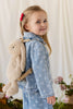 A young girl wearing a denim jacket and a hazelnut Snuggle Bunnies - Penelope Backpack - Hazelnut.
