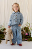 A young girl in a denim jacket and jeans holding a hazelnut Snuggle Bunnies - Penelope Backpack with an adjustable-strap plush bunny design.