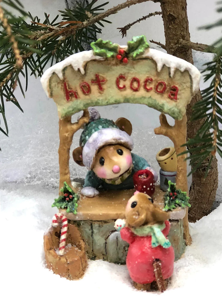 The Wee Forest Folk Tiny Collectible - Hot Cocoa Comin' Up! (Not a Toy) features two hand-sculpted mice at a snowy hot cocoa stand, accented with pine, holly, and a candy cane for a charming winter display.