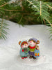 Two hand-sculpted Wee Forest Folk Tiny Collectible mice—The Little Wanderers—stand on snow under pine branches; one holds a blue lantern, and the other wears a teal coat and red scarf.