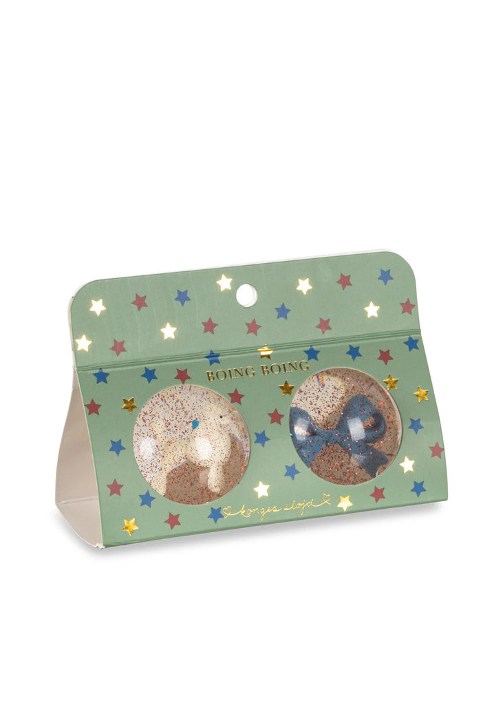 A green star-patterned package labeled "BOING BOING" displays two glittery balls—a poodle and a bow—through circular windows, capturing the playful style of the Konges Sloejd Glitter Bouncing Ball Set.